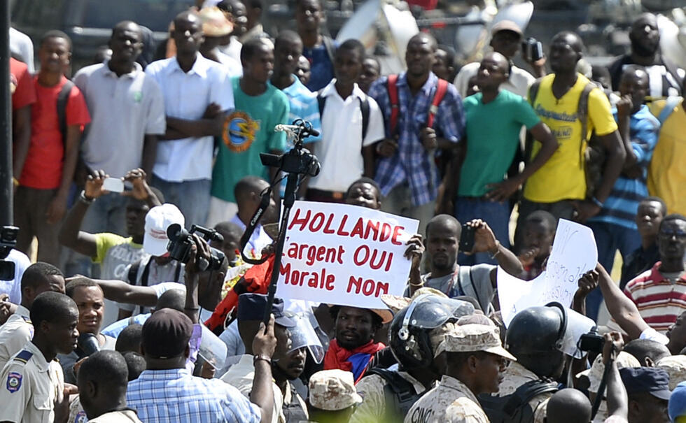 "We'll take the money, not the morals": A poster welcoming former French president François Hollande in Port-au-Prince on May 12, 2015.