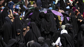 Women stand at the Kurdish-run al-Hol camp, which holds relatives of suspected Islamic State (IS) group fighters in the northeastern Hasakeh governorate, on April 18, 2025.
