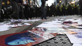 An image of Kamala Harris with the word "Genocide" written is left on the pavement as police officers line up during a protest as the Democratic National Convention (DNC) takes place in Chicago, Illin
