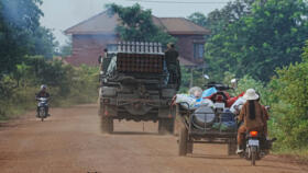 Cambodians drive behind a military vehicle in Oddar Meanchey province, Cambodia, Friday, July 25, 2025.