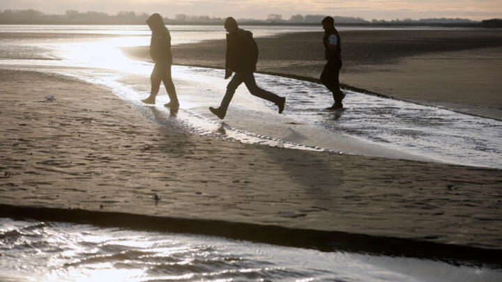 Migrants leave the beach after failing to cross the Channel and reach Britain in Gravelines, northern France.