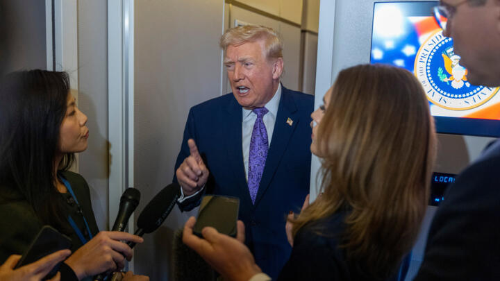 President Donald Trump speaks with reporters while in flight on Air Force One on Nov. 30, 2025.