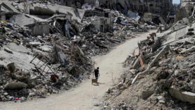 A Palestinian walks among the rubble of damaged buildings in Beit Lahia in the northern Gaza Strip, June 12, 2024.