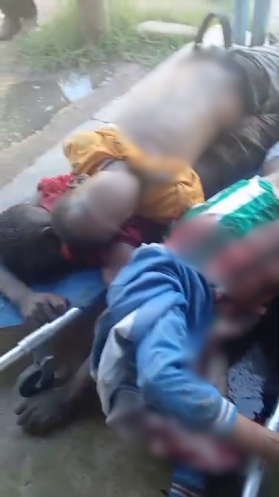 In the video from which this screen capture was taken (which we have chosen not to display due to its graphic nature), a young man can be seen among several other bodies with a fatal wound to his side. According to a weapons expert, the injury is characteristic of a gunshot wound.